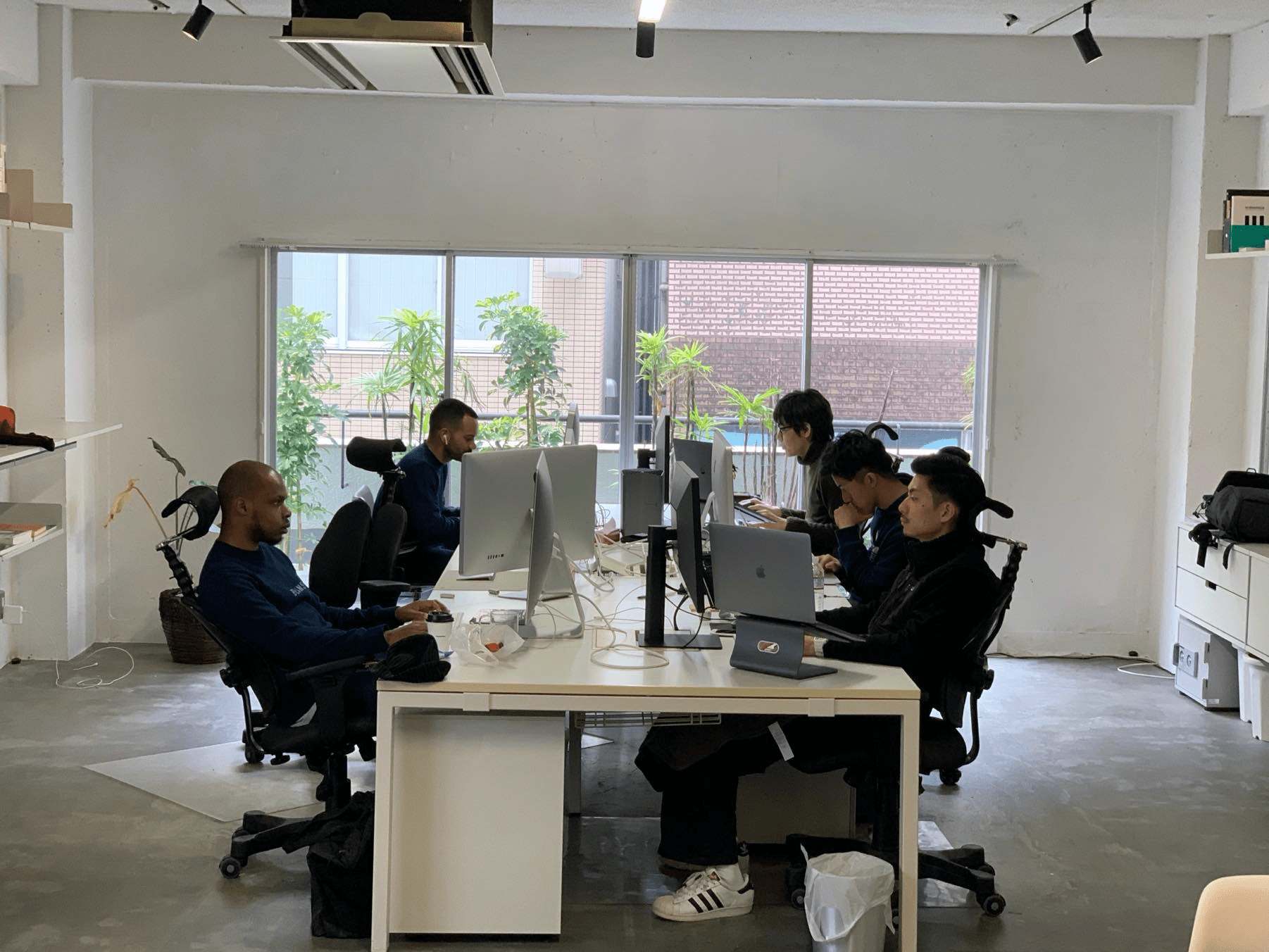 Picture of the iA Tokyo office showing five men working at a large shared desk